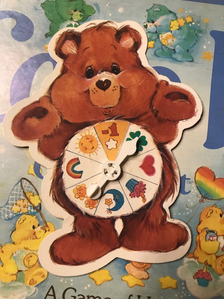 A Care Bear whose belly makes up the spinner