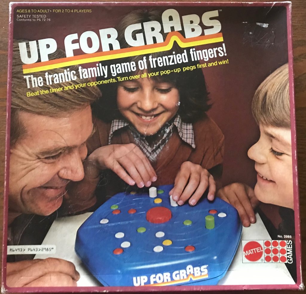 Cover shows family of 3 leaning over the game piece