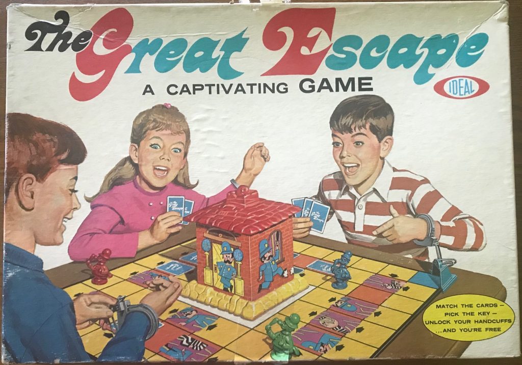 Three children looking excited while handcuffed to a game board