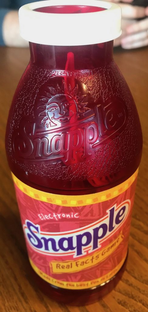 The Snapple bottle is red and has a label and everything