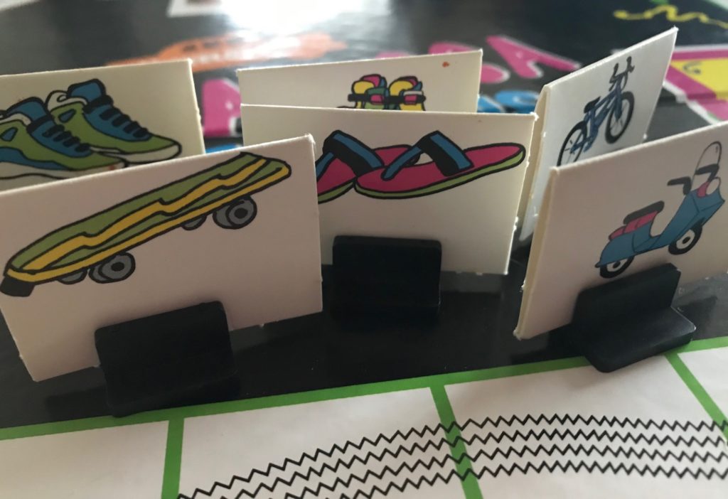 Pawns are stock paper standees with shoes, skateboard, bicycle, scooter