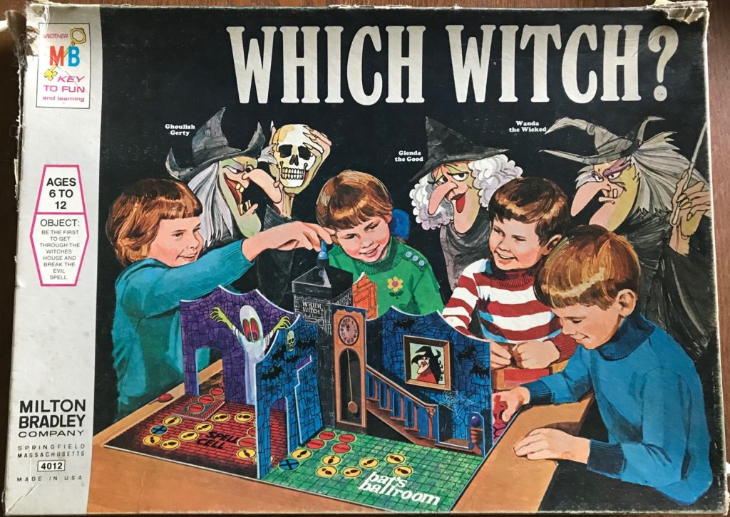 Four kids surround a 3-d board of a haunted house